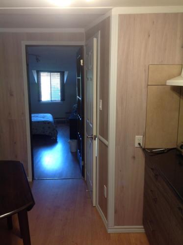 a hallway with a bedroom and a bed in a room at Les appartement 4 saisons des iles in Saint-Gédéon