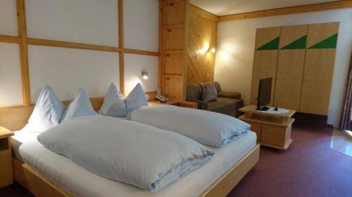 ザールバッハ・ヒンターグレムにあるAppartementhotel Hechenbergのベッドルーム(白い枕の大型ベッド1台付)