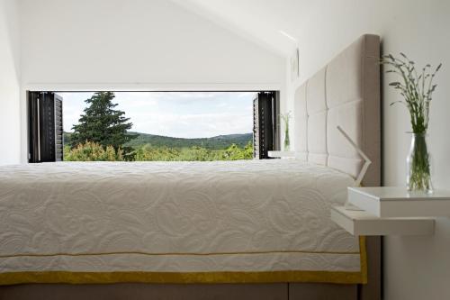 a bedroom with a bed and a large window at Holiday House KALIMERO in Primošten