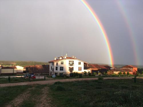 a rainbow over a white house with at Hotel Valdelinares (Soria) in Valdelinares