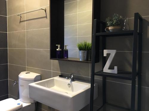 a bathroom with a sink and a toilet at Cozy Hyve Soho Suites in Cyberjaya