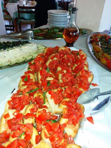 a pizza with tomatoes on it on a table at Frank's Hotel in Capoliveri