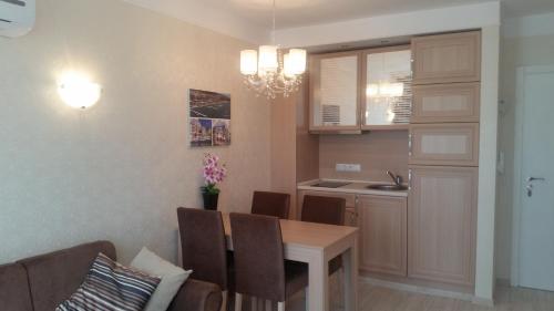 a kitchen and dining room with a table and chairs at Harmony Suites Apartment in Sveti Vlas