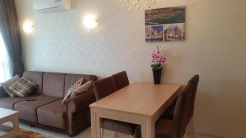 a living room with a couch and a table at Harmony Suites Apartment in Sveti Vlas