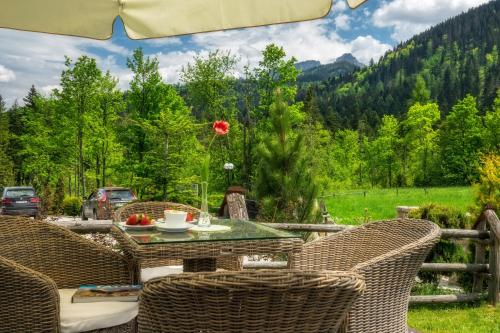 a patio with a table and chairs with a view at Hotel Eco Tatry Holiday& Spa in Kościelisko