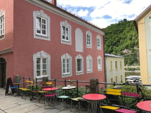 
a row of tables with chairs and umbrellas in front of a building at das-hornsteiner in Passau
