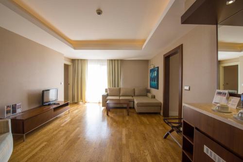a living room with a couch and a television at Ramada Plaza Antalya in Antalya