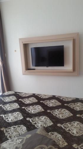 a bedroom with a flat screen tv on the wall at Harmony Suites Apartment in Sveti Vlas