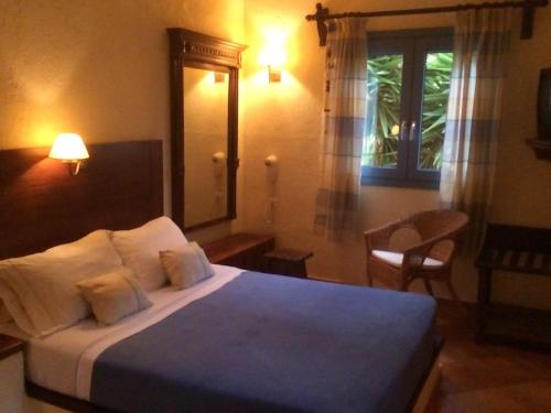 a bedroom with a bed with two pillows and a window at Porto Sisi Hotel Apartments in Sissi