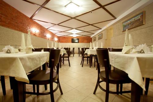 un restaurante con mesas y sillas con mantel blanco en Castle, en San Petersburgo