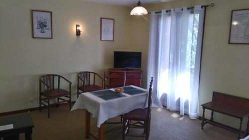 a living room with a table and chairs and a window at Hotel des Arcades in Céret