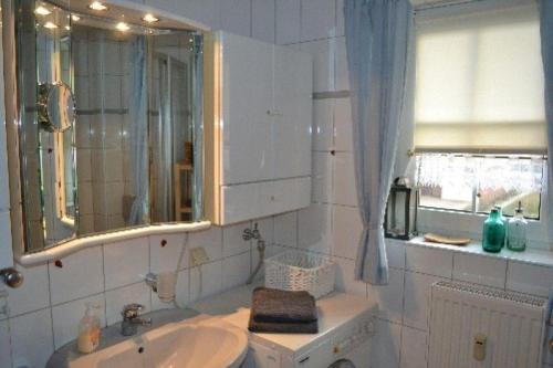 ein Bad mit einem Waschbecken und einem Spiegel in der Unterkunft Appartement Beisel unter Reet in Garding