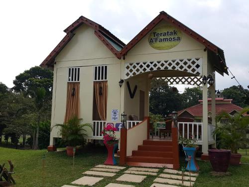 a small white house with a sign on it at D Savoy Famosa Condo in Melaka