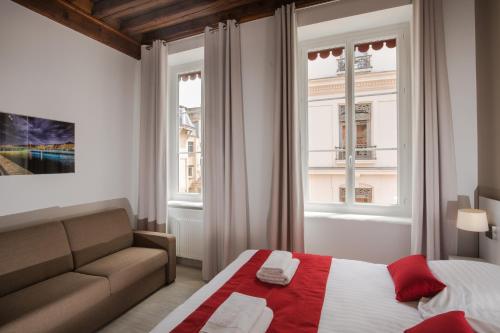 a bedroom with a bed and a couch and a window at Lyon Cosy Stay in Lyon