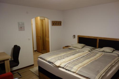 a bedroom with a large bed and a desk at Gasthof Dietrichshorn in Unken