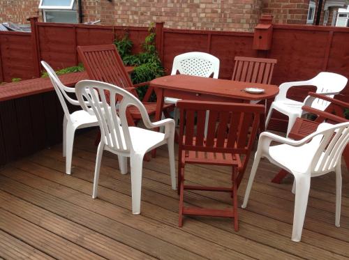 a group of chairs and a table on a deck at Sherwood Lodge in Skegness
