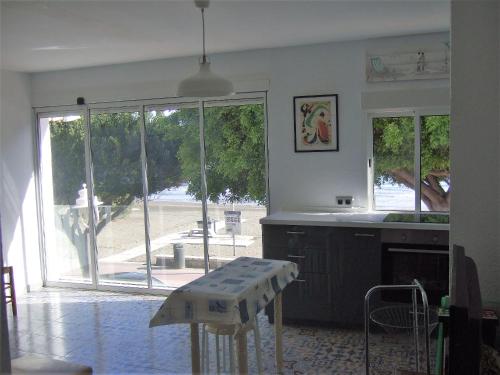 a kitchen with a table in front of a large window at Beachfront House in Málaga