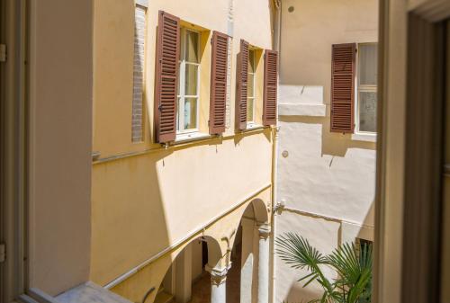 ファーノにあるPalazzo Rotatiの茶褐色の窓と植物のある建物