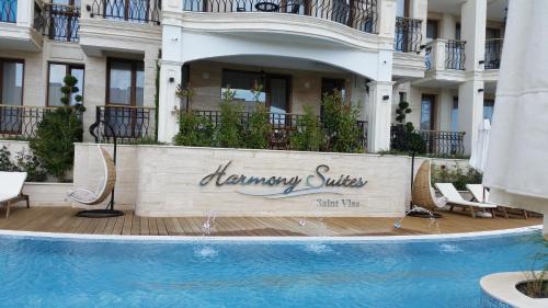 a hotel with a swimming pool in front of a building at Harmony Suites Apartment in Sveti Vlas