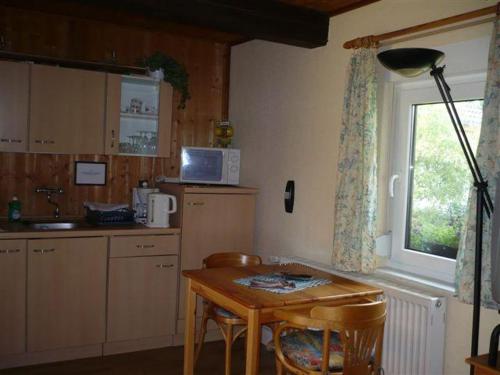 een keuken met een tafel en een raam en een tafel bij Pension-Drews-Ferienzimmer-3 in Grubenhagen