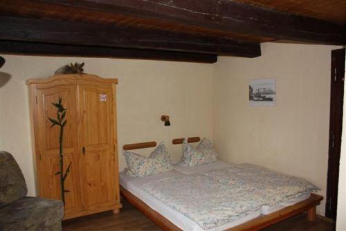 a bedroom with a bed and a wooden cabinet at Pension-Drews-Ferienzimmer-3 in Grubenhagen