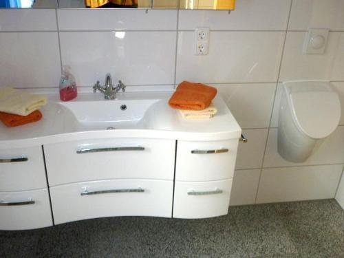 Baño blanco con lavabo y aseo en Ferienwohnung-Draeger, en Mardorf