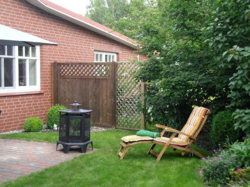 a yard with two chairs and a table and a fence at Ferienwohnung-Abendroete in Lüdersburg