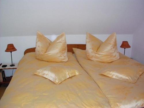 2 almohadas sentadas encima de una cama en Ferienwohnung-Mund, en Pillnitz