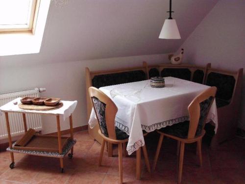 une salle à manger avec une table et un chiffon de table blanc dans l'établissement Ferienwohnung-Mund, à Pillnitz