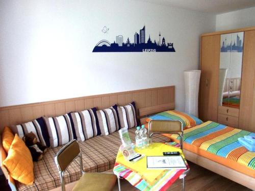 ライプツィヒにあるFerienapartment-Leipzig-Plagwitzのソファ、テーブル、椅子が備わる客室です。