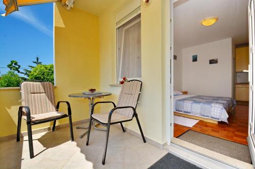 a balcony with a table and chairs and a bed at Apartments Andreja in Kožino