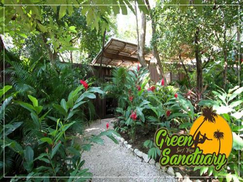 un giardino con un cartello che dice cortile verde del santuario di Green Sanctuary Hotel a Nosara