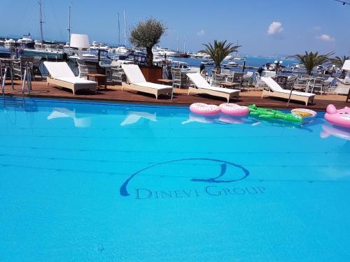 a large swimming pool with chairs and a marina at Hotel Palace Marina Dinevi in Sveti Vlas