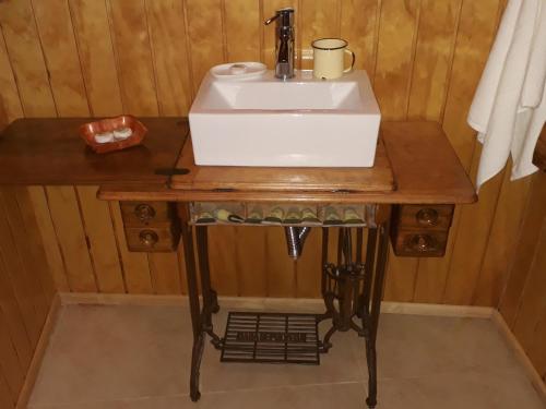 a sink on a wooden table in a bathroom at Cabañas y Casa Kauken in Puerto Natales