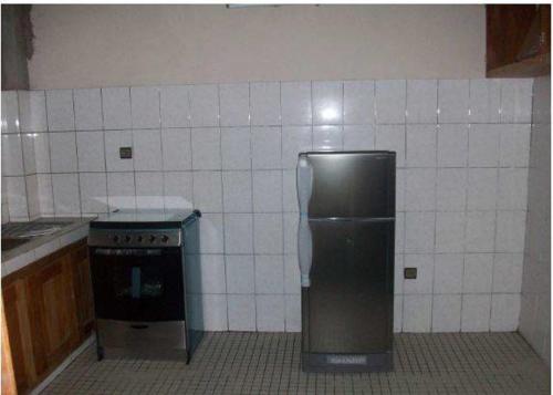 a kitchen with a stainless steel refrigerator and a stove at Rose Garden Apartments in Limbe