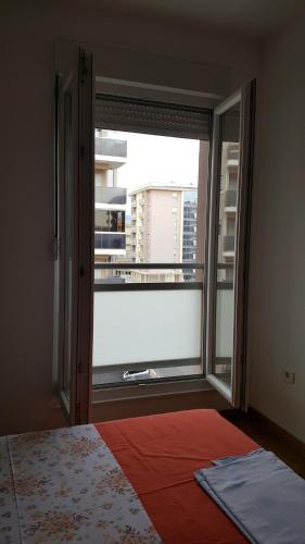 a bedroom with a large window with a view of a city at Zebra in Podgorica