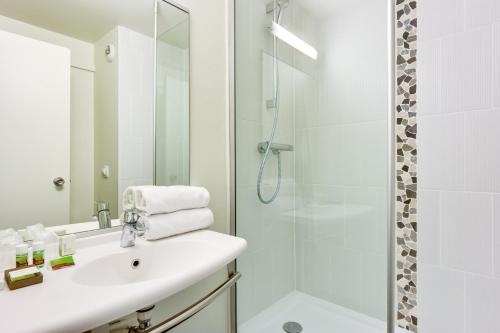 a bathroom with a sink and a shower at Ibis Styles Bobigny Centre Préfecture in Bobigny