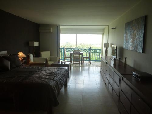 1 dormitorio con 1 cama y sala de estar con balcón. en European Luxur Tortola 5318, en Cul de Sac