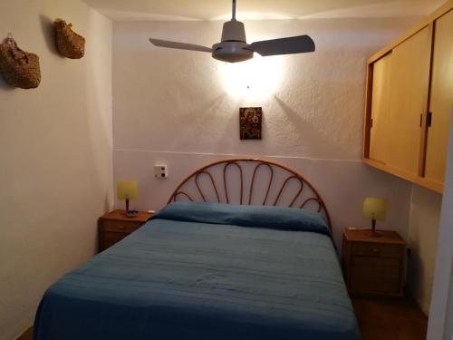 um quarto com uma cama azul e uma ventoinha de tecto em Villa Caterina em Mondello
