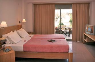 a hotel room with a bed and a television at Maria Apartments in Agia Pelagia