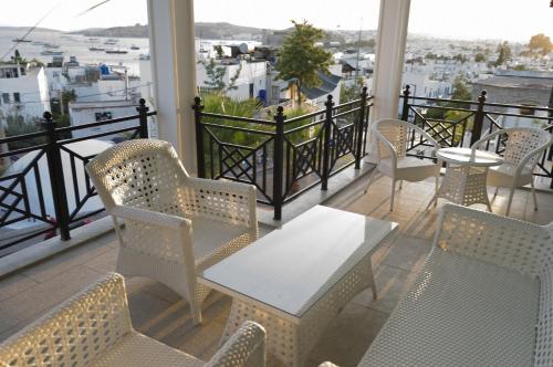 a balcony with tables and chairs and a view of a city at Ena Boutique Hotel & Residences in Bodrum City