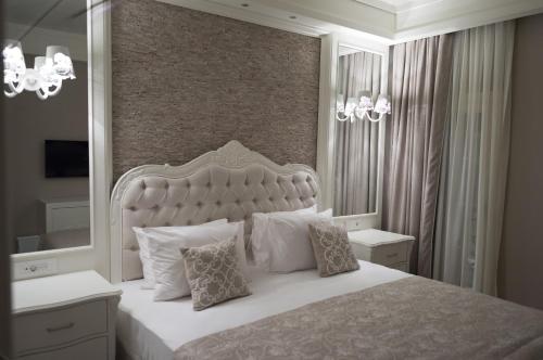 a bedroom with a large white bed with pillows at Ena Boutique Hotel & Residences in Bodrum City