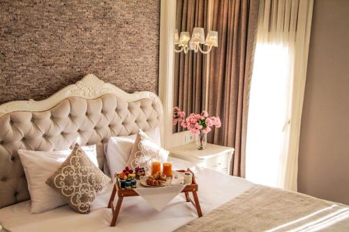 a bedroom with a large white bed with a table at Ena Boutique Hotel in Bodrum City