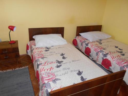 1 dormitorio con 2 camas con flores en las sábanas en Apartments Ema, en Šibenik