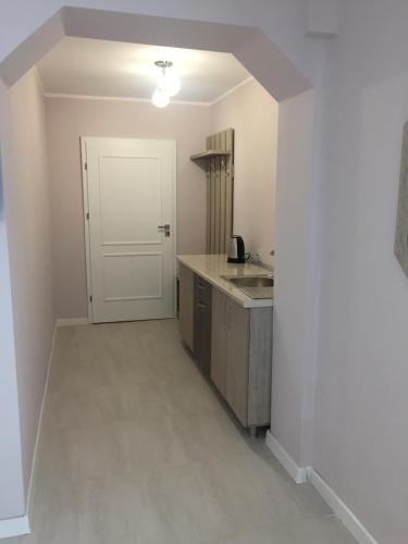 an empty kitchen with a sink and a door at Casa Meyra in Jupiter