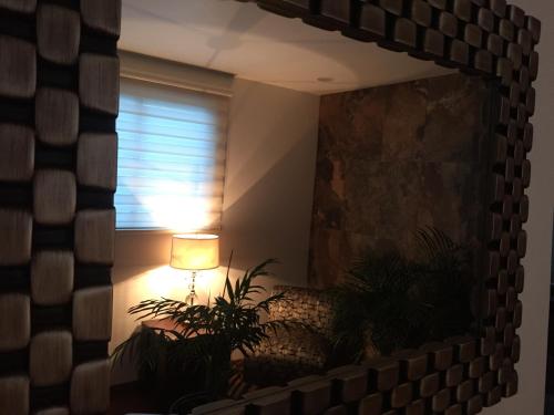 a mirror in a room with a lamp and a window at Casa Molcajete in Mexico City