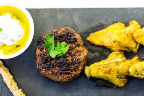 a plate of food with fried food and a bowl of condiments at Mikro Livadi Special Lodges - Has an Eco Salt water pool - 150m from the beach in Episkopí- Rethimno