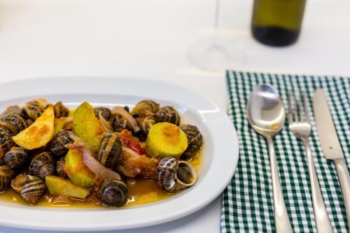 a plate of food with mushrooms and fruit on a table at Mikro Livadi Special Lodges - Has an Eco Salt water pool - 150m from the beach in Episkopí- Rethimno