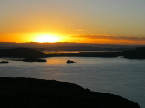 a sunset over a large body of water at Marlon's House Puno-Peru in Puno