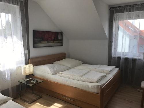 ein Schlafzimmer mit einem Bett in einem Zimmer mit Fenstern in der Unterkunft Bella Vita in Rust